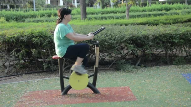 Mogen kvinna utövar på spinning cykel — Stockvideo