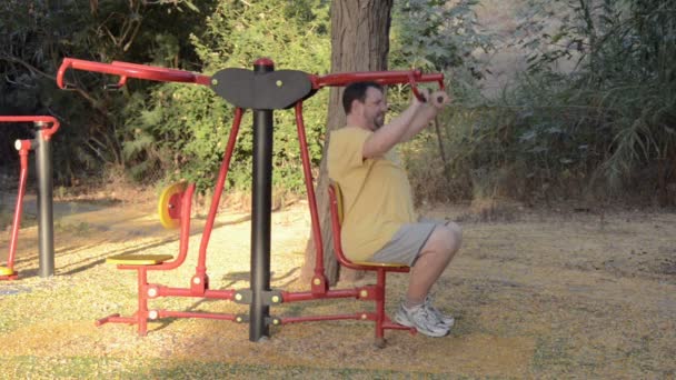 Hombre maduro haciendo ejercicio en la máquina de tirar hacia abajo — Vídeos de Stock