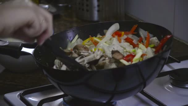 Повар добавляет грибы к куриной грудке — стоковое видео