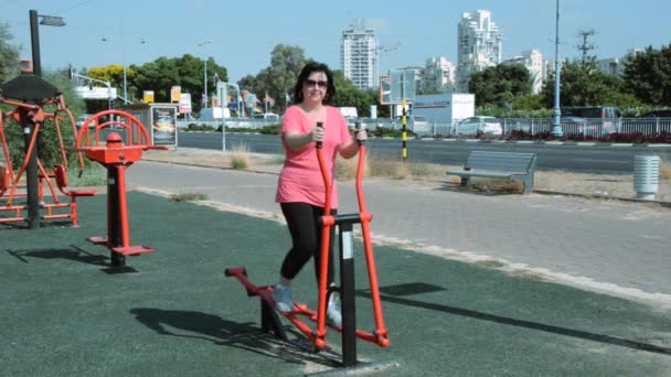 Woman exercises on elliptical cross — Stock Video