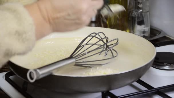 Προσθέτοντας τυρί γραβιέρα σε σάλτσα Μορνέ στο τηγάνι — Αρχείο Βίντεο