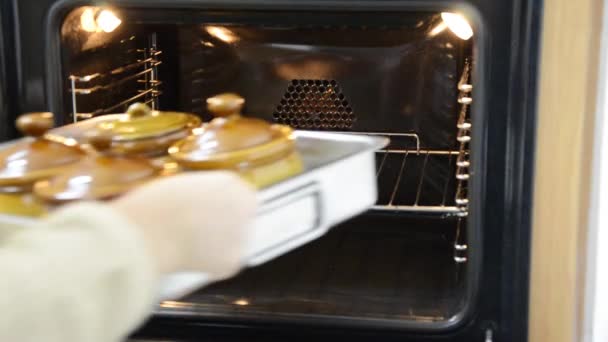 Brengen van klei kookpotten in een koude oven — Stockvideo