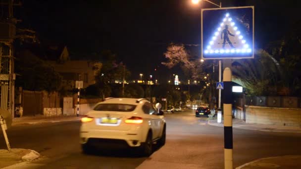 Автомобиль проезжает мимо мигающего знака пешеходного перехода — стоковое видео
