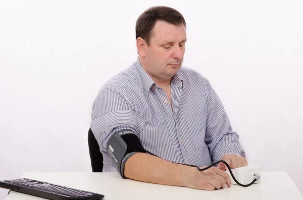 Over weighted man is concerned about his blood pressure — Stock Photo, Image