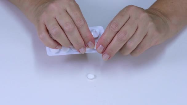 Fingers pulling tablets out of the package — Stock Video