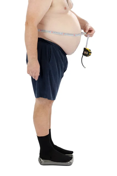 Overweight man measures his waist Stock Image