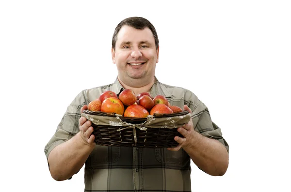 Happy farmer holding a basket of ripe red apples — Stock Photo, Image