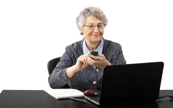 Velha senhora de negócios ligando por telefone durante a conversa skype — Fotografia de Stock