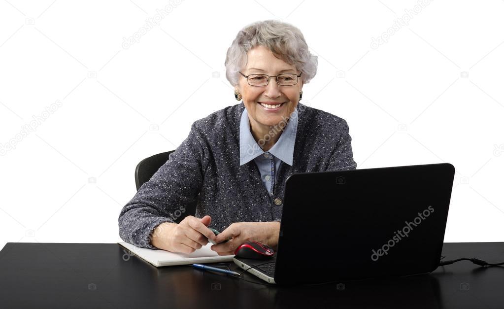 Grey haired old business lady laughing during skype conversation