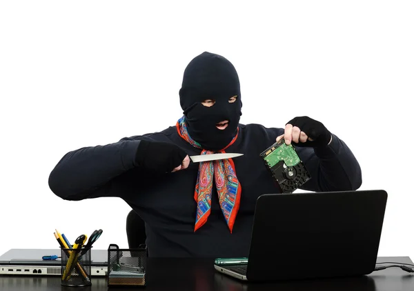 Burglar holding a knife and hard disk speaking on Skype — Stock Photo, Image