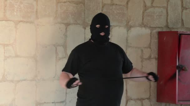 Thug in balaclava ambushing with noose — Stock Video