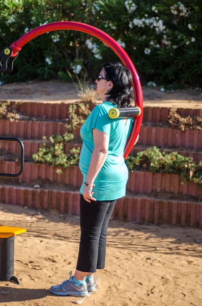 Mujer haciendo ejercicio en una máquina de masaje de espalda de cintura — Foto de Stock