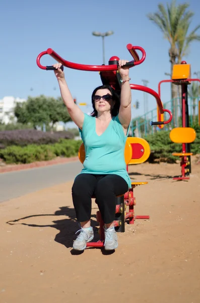 Mujer haciendo ejercicio en Lat Tire de la máquina al aire libre — Foto de Stock