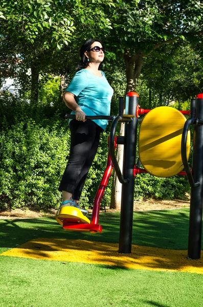 Woman swinging on a surfboard station outdoor — Stock Photo, Image