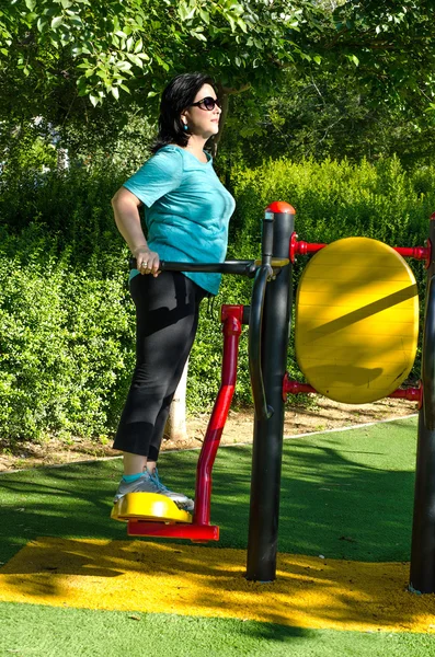 Mujer haciendo ejercicio en una estación de máquinas de intercambio de aire al aire libre — Foto de Stock