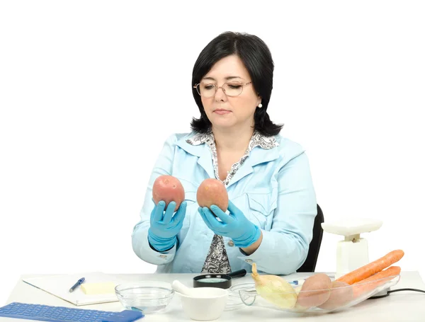 Expert looking at two red potatoes in laboratory — Stock Photo, Image