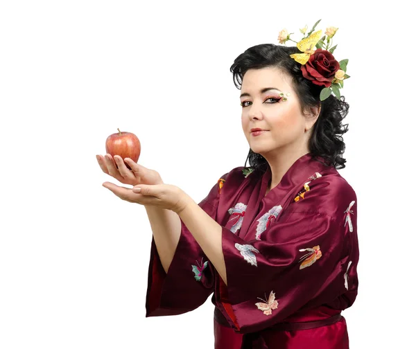 Кимоно женщина предлагает красное яблоко — стоковое фото
