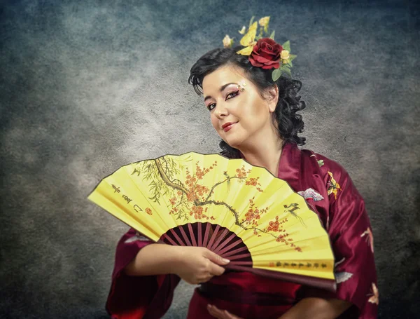 Svrchních portrét starší ženy kimono s ventilátorem — Stock fotografie