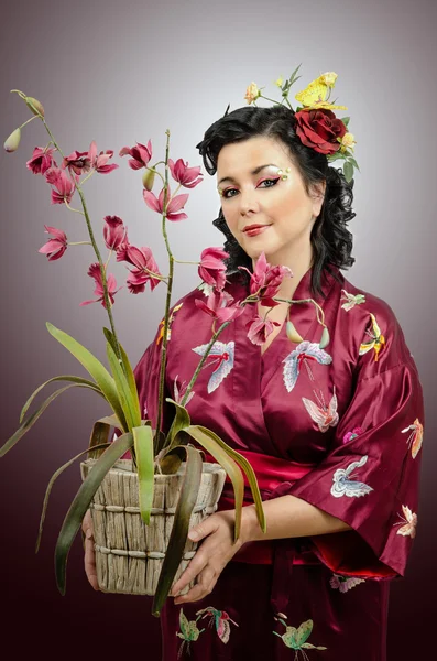 Kimono mujer caucásica sosteniendo una orquídea —  Fotos de Stock