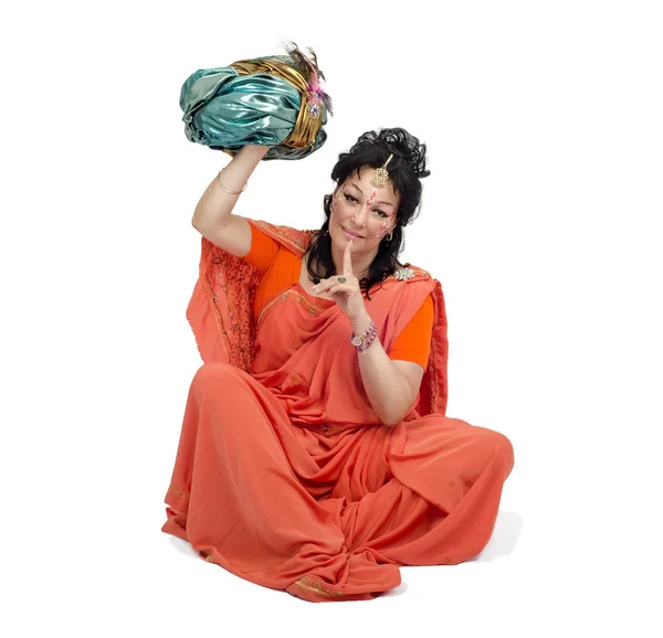 Vrouw in oranje sari vergadering en houdt tulband — Stockfoto