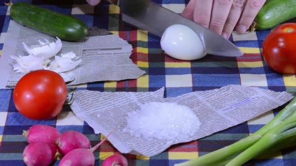 Cutting egg on newspaper — Stock Video