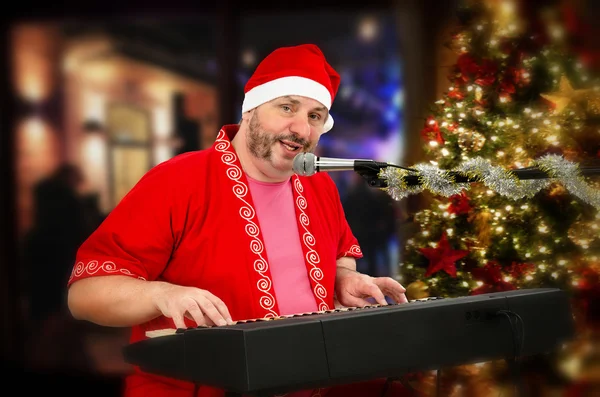 Bearded Santa Claus playing digital piano and singing — Stock Photo, Image