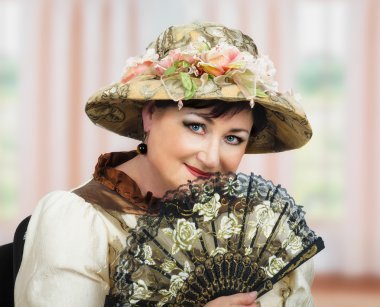 Orta yaşlı kadın oyuncu ile fan Retro şapkasıyla poz