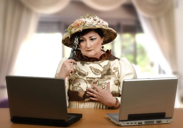 Mujer con ropa vieja leyendo las noticias en línea — Foto de Stock