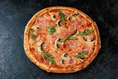 Siyah beton arka planda lezzetli bir pizza. Sıcak pizzanın en üst görüntüsü. 