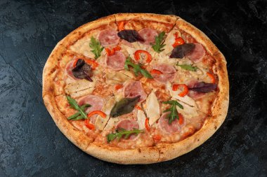 Siyah beton arka planda lezzetli bir pizza. Sıcak pizzanın en üst görüntüsü. 