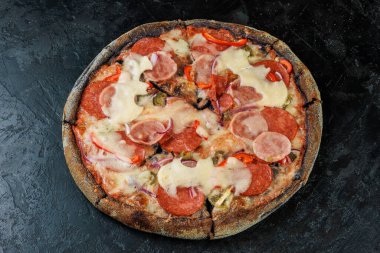 Siyah beton arka planda lezzetli bir pizza. Sıcak pizzanın en üst görüntüsü. 
