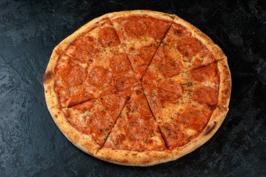Siyah beton arka planda lezzetli bir pizza. Sıcak pizzanın en üst görüntüsü. 