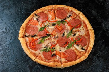 Siyah beton arka planda lezzetli bir pizza. Sıcak pizzanın en üst görüntüsü. 