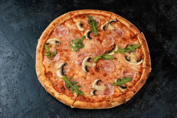 Siyah beton arka planda lezzetli bir pizza. Sıcak pizzanın en üst görüntüsü. 