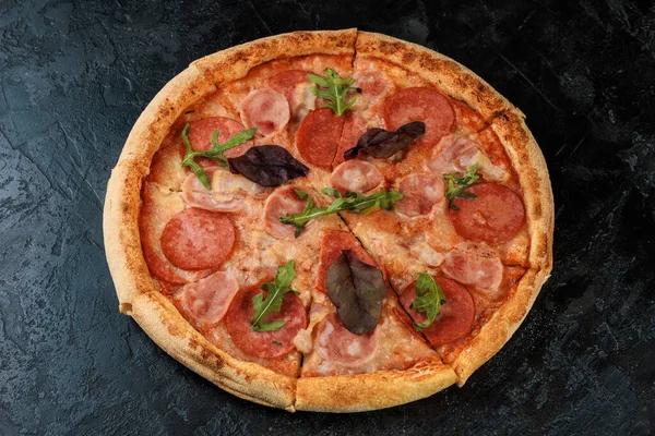 Siyah beton arka planda lezzetli bir pizza. Sıcak pizzanın en üst görüntüsü. 
