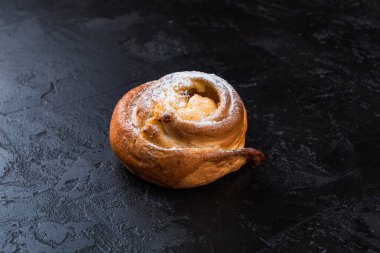 Karanlık bir masada taze pişmiş lezzetli çörek. Pastaneden gelen lezzetli pişmiş yiyecekler. Siyah arkaplan.