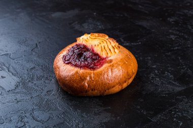 Karanlık bir masada taze pişmiş lezzetli çörek. Pastaneden gelen lezzetli pişmiş yiyecekler. Siyah arkaplan.