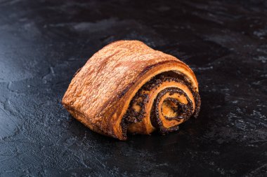 Karanlık bir masada taze pişmiş lezzetli çörek. Pastaneden gelen lezzetli pişmiş yiyecekler. Siyah arkaplan.
