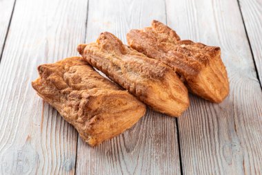 Beyaz ahşap bir masada taze pişmiş lezzetli çörek. Pastaneden gelen lezzetli pişmiş yiyecekler. Beyaz arkaplan.