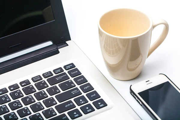 Fermer tasse de café avec ordinateur portable et téléphone cellulaire isolé sur blanc — Photo