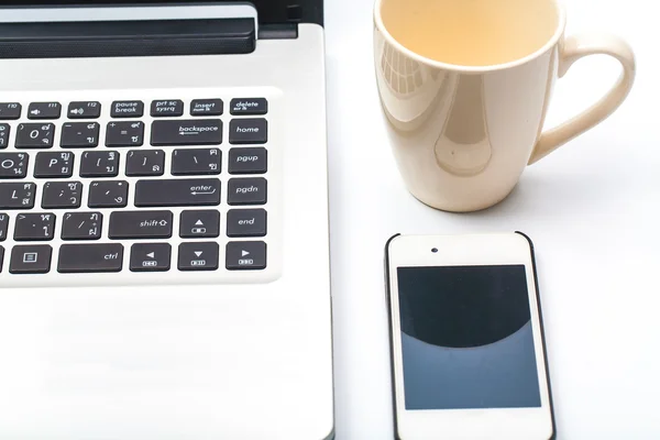 Koffiekopje met laptop en mobiele telefoon geïsoleerd op wit close-up — Stockfoto