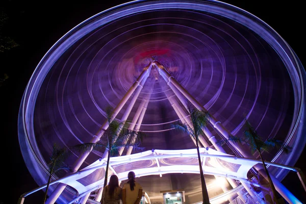 Колесо обозрения в движении в парке развлечений ночью — стоковое фото