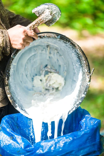 Agronom ruka drží nádrž na mléko z gumovníku — Stock fotografie