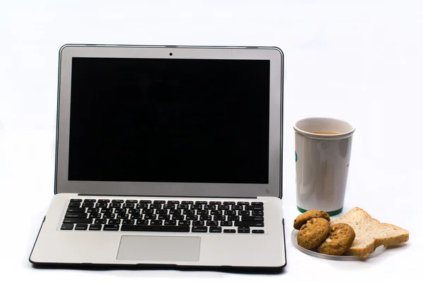 Scrivania bianca con computer portatile, pane e tazza di caffè — Foto Stock