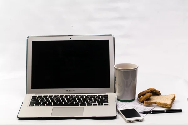 Portatile con cellulare, banca del libro, biscotti, pane e tazza di caffè — Foto Stock