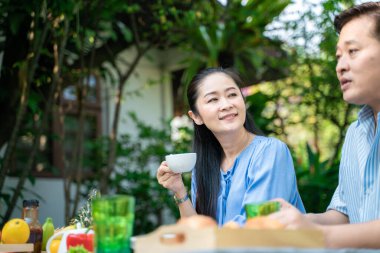 Emekli çift bahçede kahve içip kadeh kaldırıyor, Yaşam Tarzı Konsepti.