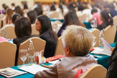 Bir grup insan otel odası iş toplantısında seminer veriyor.