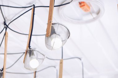 Kafenin tavanında sanat eseri bir lamba demeti.