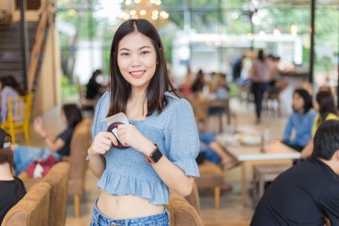 Kafede kahve siparişi bekleyen güzel Asyalı kadınlar arka plandaki insanları bulanıklaştırdı.