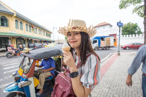 Beautiful women eat ice cream while travel in urban city lifestyle walking on downtown street of Bangkok City, Thailand, Concept Travel